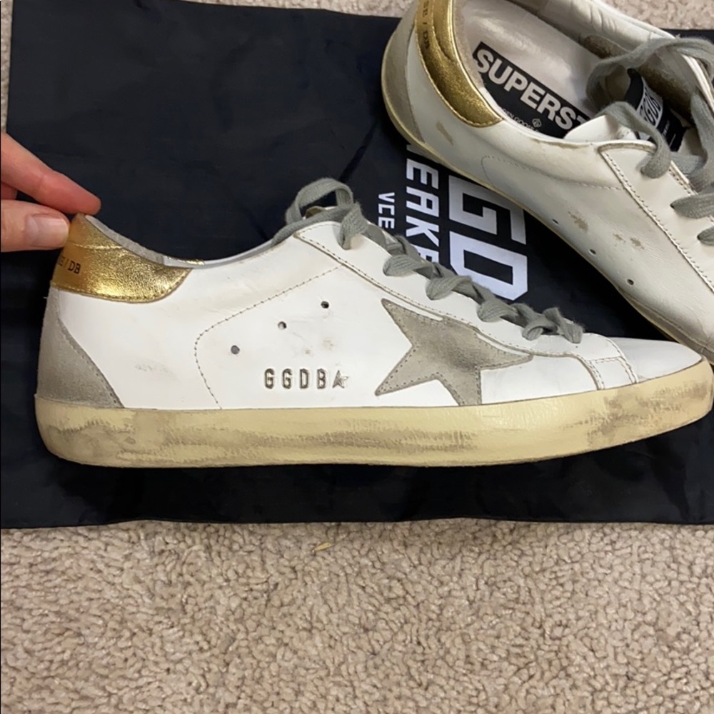 Golden Goose Sneakers with white and gold detail.